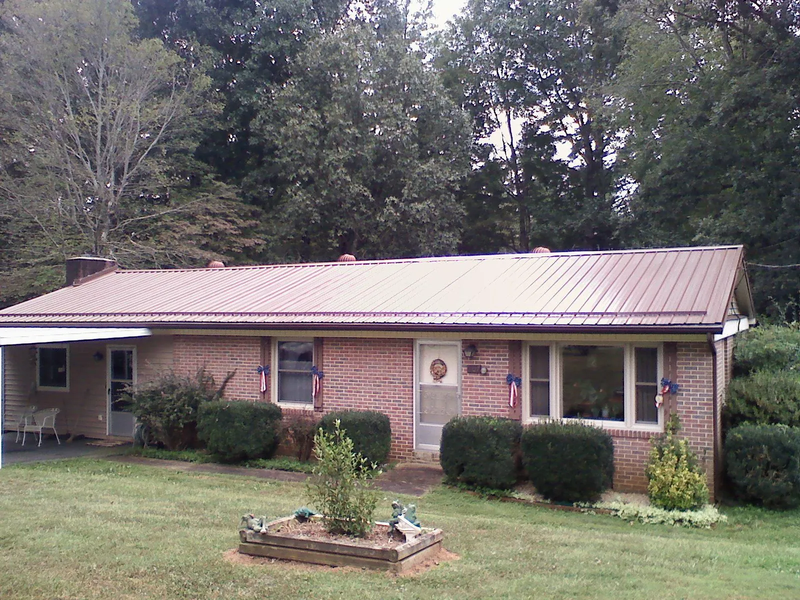 Bronze metal roof on a brick ranch home with a carport in Hollywood